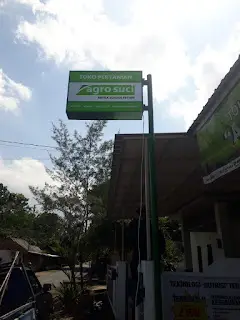 Neon box kotak minimalis Agro Suci dengan logo besar, cocok untuk usaha pertanian di Jember