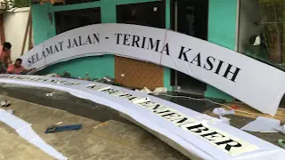 proses pemasangan stiker papan nama bertuliskan selamat datang antar kota